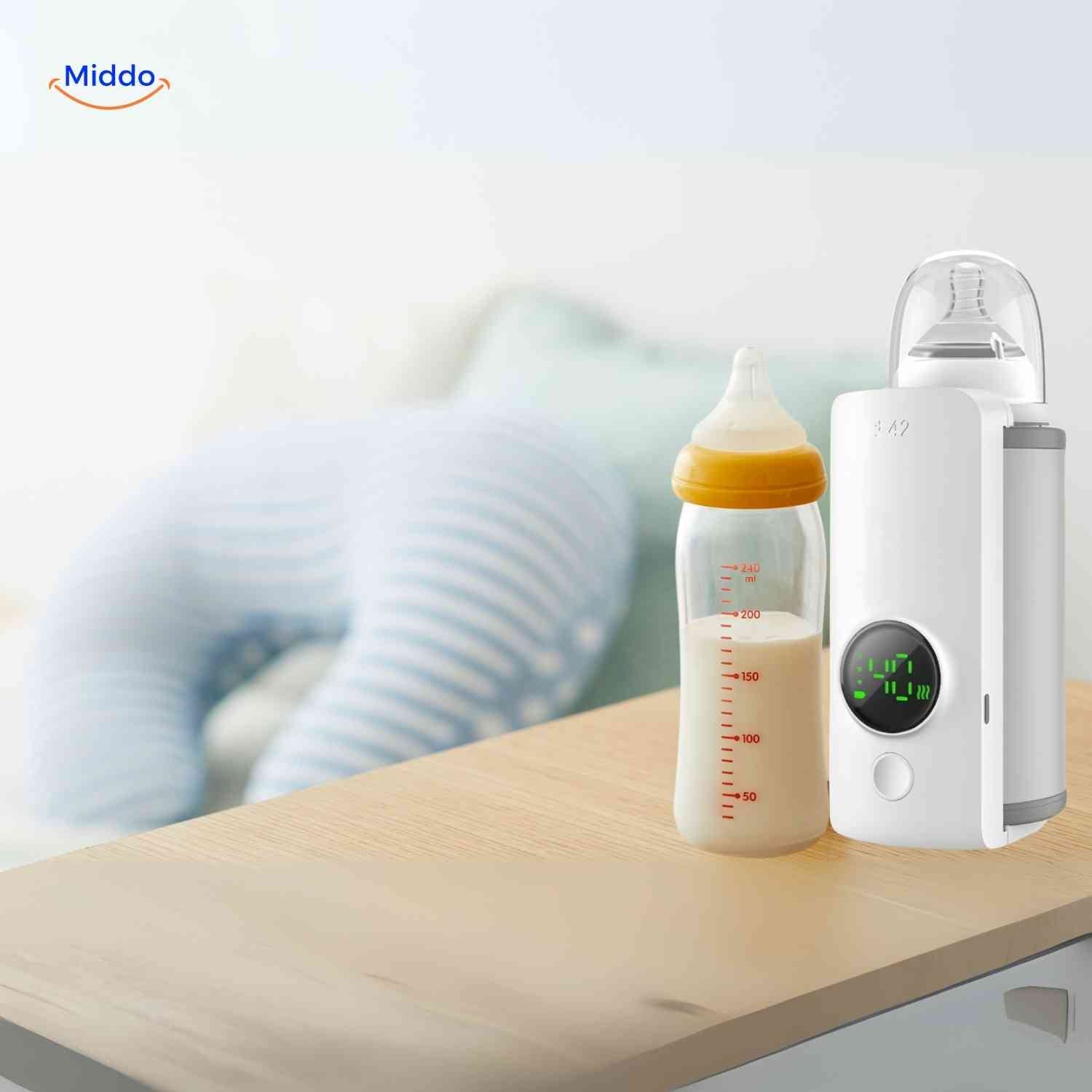 warmiboo flesverwarmer naast babyfles op tafel www.middo.nl