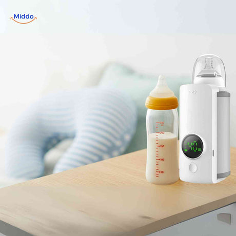 warmiboo flesverwarmer naast babyfles op tafel www.middo.nl