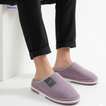 warmtique pantoffels zacht katoen antislip en huiscomfort man zittend met lila pantoffels www.middo.nl